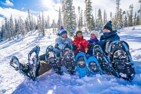 A group of snowshoers enjoy hot chocolate after their guided snowshoe tour at Winter Park Colorado Ski Resort.