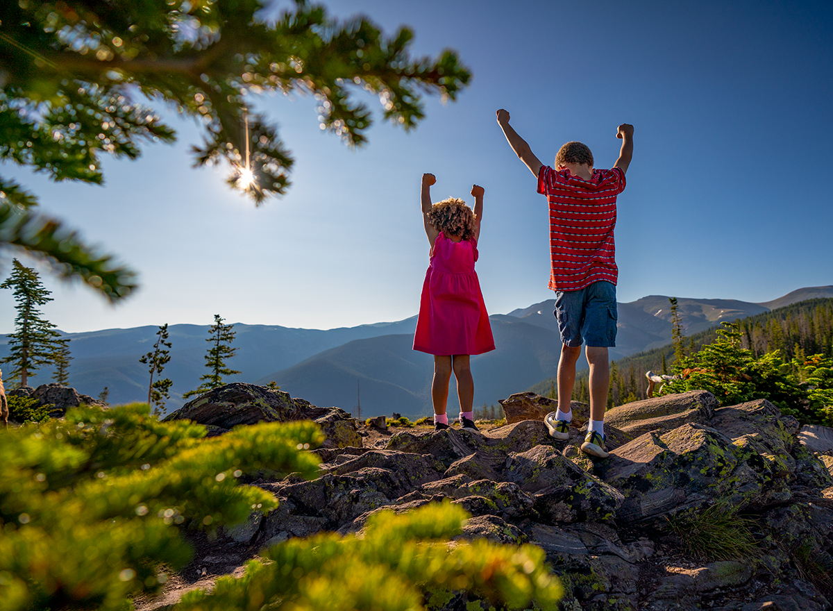 Two children at the top of the mountain with their fists up