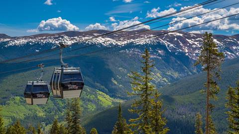 scenic gondola ride cabins traveling up the mountain for summer sightseeing at winter park resort in colorado