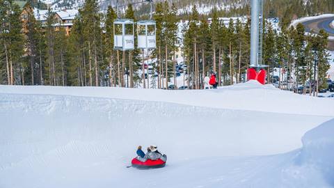 person sliding down hill during snow tubing at coca cola tube hill at winter park resort