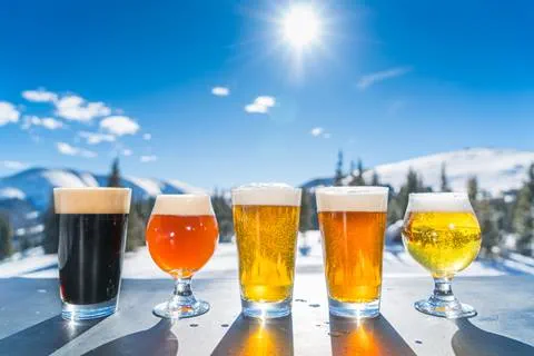 5 beers lined up with winter park ski resort in the background
