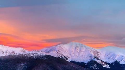 sunset over snow covered mountains