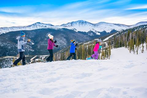 Family snowshoeing at Winter Park Resort with the continental divide in the background