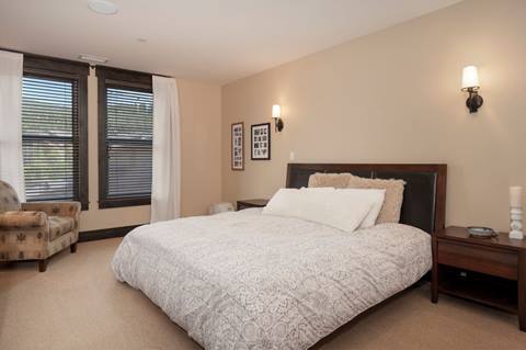 an upscale bedroom with white bedding and large windows at parry peak lofts vacation rentals in winter park colorado