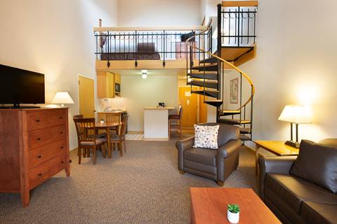 a spacious lofted studio suite layout with a spiral staircase, dining area, and kitchen setup at the vintage hotel near winter park resort