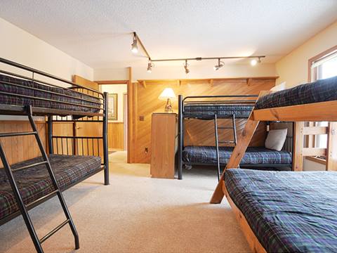 A bedroom with multiple bunk beds at  the 61 Jabberwocky vacation rental at Winter Park Resort 