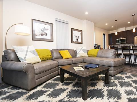 A living room with a grey couch in an Arrow Townhome vacation rental at Winter Park Resort