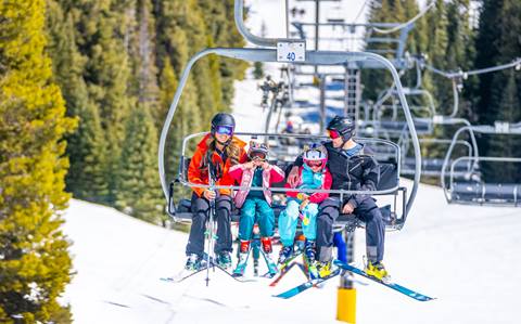Family skiing & riding chairlift at Winter Park Resort in Colorado