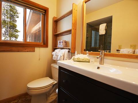Bathroom with the sink in the foreground and the toilet in. the background. 