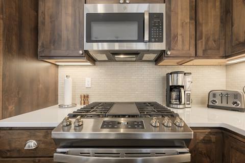 Stainless oven and microwave with backsplash, toaster, and coffee maker.