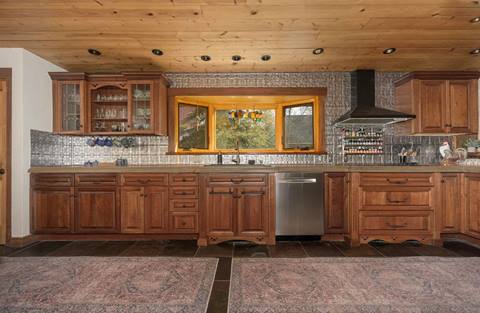 Kitchen with wood cabinets, stainless steel appliances, and decorative tile backsplash.