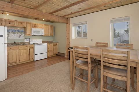 Basement dining room with a wooden table and four chairs seated around it. 