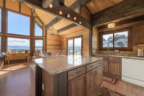 Kitchen with granite island, open windows, and a view of the mountains. 