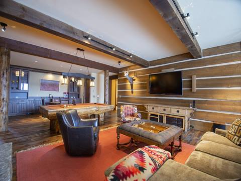 Licing room with couch, coffee table, and mounted television. 