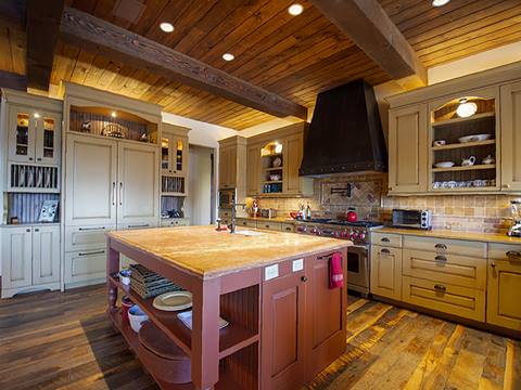 Kitchen with a red wooden island in the middle. 