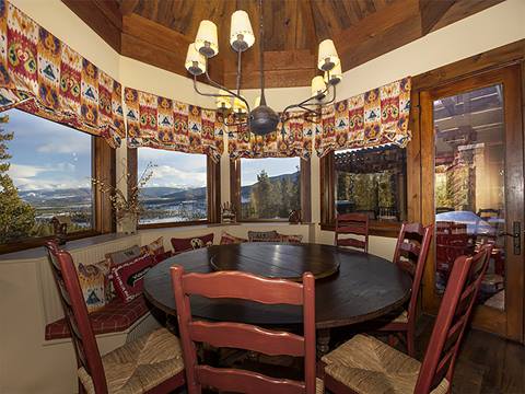 Rich dining room with intricate wallpaper trim at the top of the walls. 