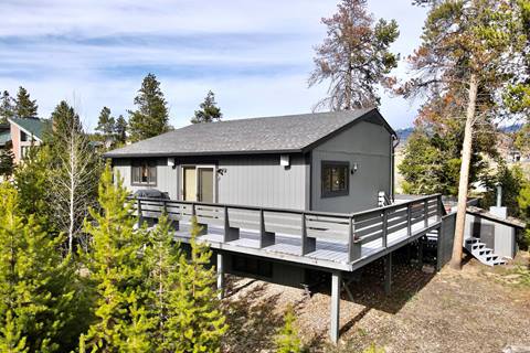 View of the exterior of a gray house in the mountains. 