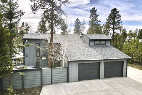 View of the exterior of a gray house in the mountains. 