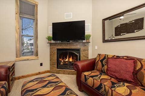 Living room with fireplace and bright colored furniture.