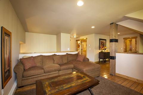 Game room in the background with a couch and coffee table in the front. 