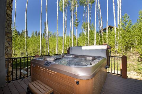 6-person hot tub with the top pulled back. Aspens in the background. 
