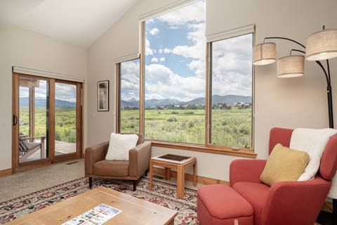 Interior with carpeted living room and mountain view outside the windows.