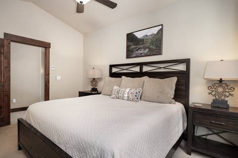 Bedroom with king bed, dark wood furniture, and neutral décor.