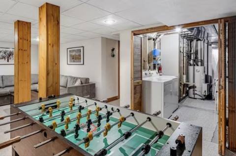 Basement game area with foosball table, washer and dryer, and utility area.
