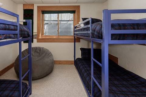 Bedroom with two sets of twin bunk beds and a bean bag chair.