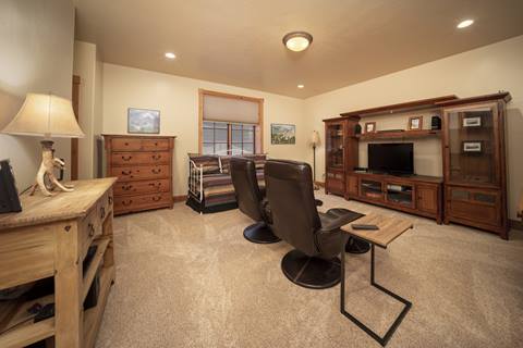 Family room with two leather recliners, a wooden entertainment center, and a daybed with striped bedding.