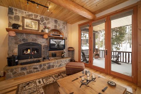 Closer view of the hearth, TV niche, and patio doors to the snowy porch.
