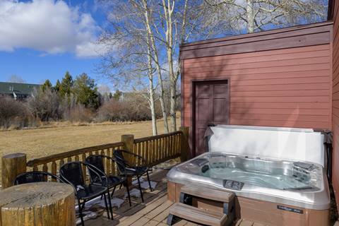 Outdoor deck with private hot tub and forest views.
