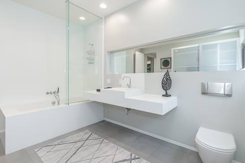 Alternate angle of bathroom with floating sink, tub, and modern fixtures.