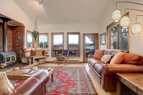 Cozy living room with richly colored rugs and leather couches and a nice view outside. 