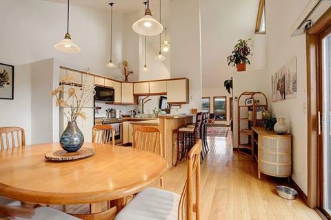 Open dining area with wooden table and chairs adjacent to the kitchen and breakfast bar.