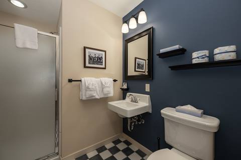 Bathroom with blue accent wall, toilet, sink, and framed black-and-white photo.