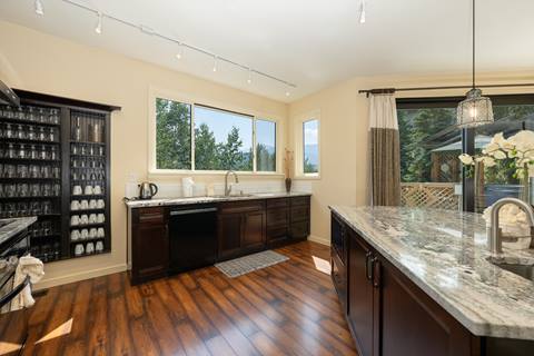 Modern kitchen with granite countertops, dark cabinets, and island seating.
