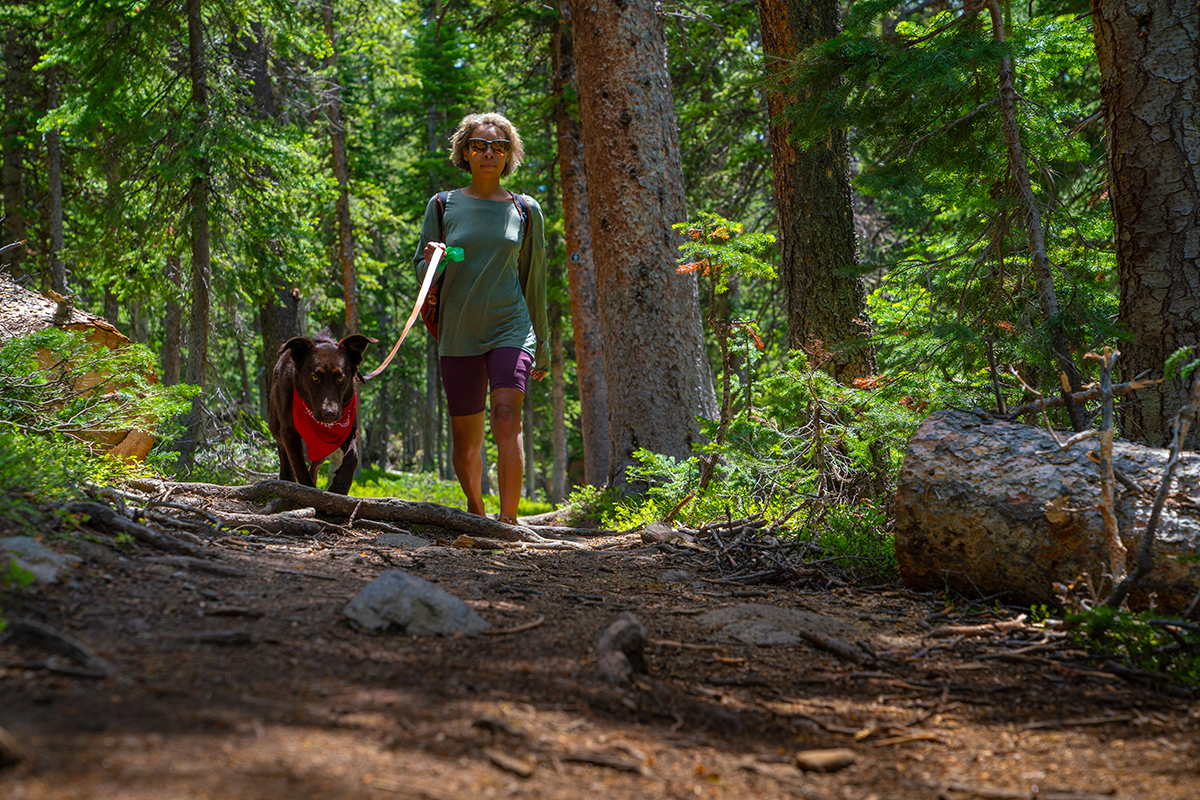 Women walking her dog through the woods