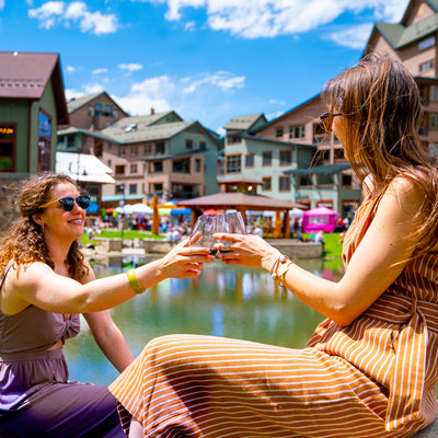 two people in front of a pond with wine at Village Uncorked