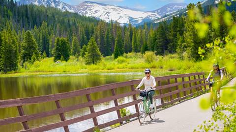 woman exploring scenic summer terrain on a riverside electric bike tour at winter park resort in colorado