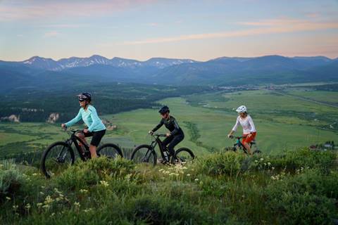 three women riding on scenic mountain biking trails at winter park resort across the fraser valley in colorado