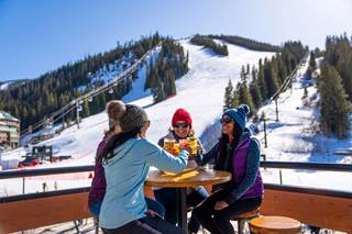 Women cheersing beers at the base of Winter Park ski resort Resort