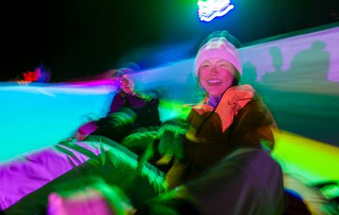 two friends snow tubing during night snow tubing at winter park resort