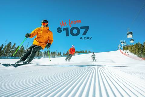 Skiers at Winter Park Resort on groomed run and sunny blue sky day