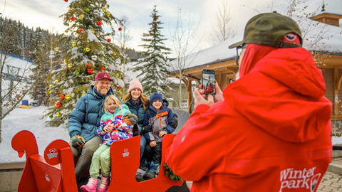 Family in a sleigh getting their photo taken at Winter Park Resort