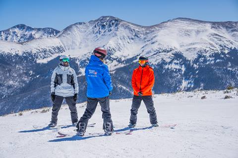 Two snowboarders taking a lesson with an instructor at Winter Park Resort 